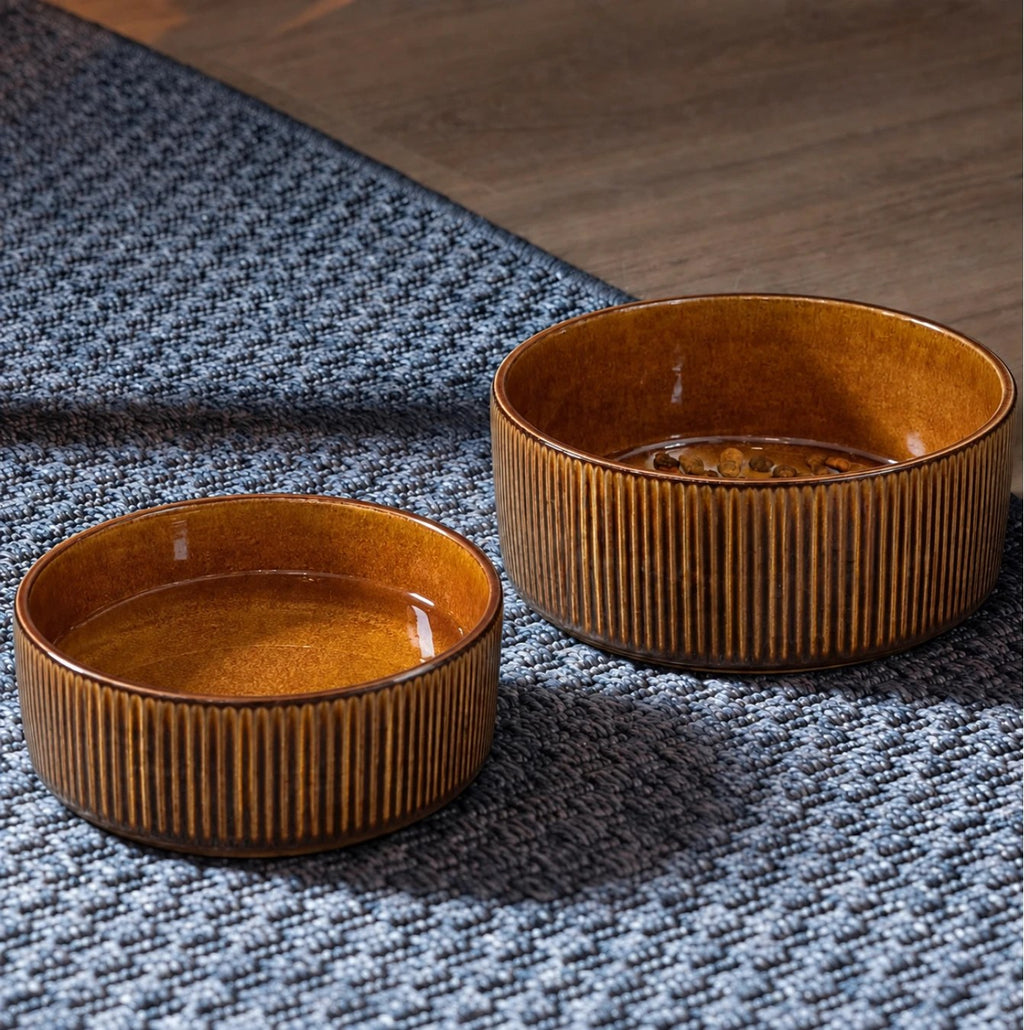 Large and small brown ceramic bowls on a rug