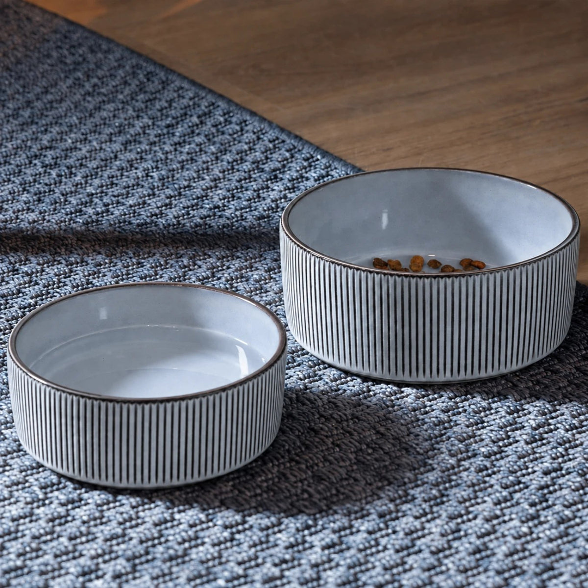 Large and small grey ceramic bowls on a rug