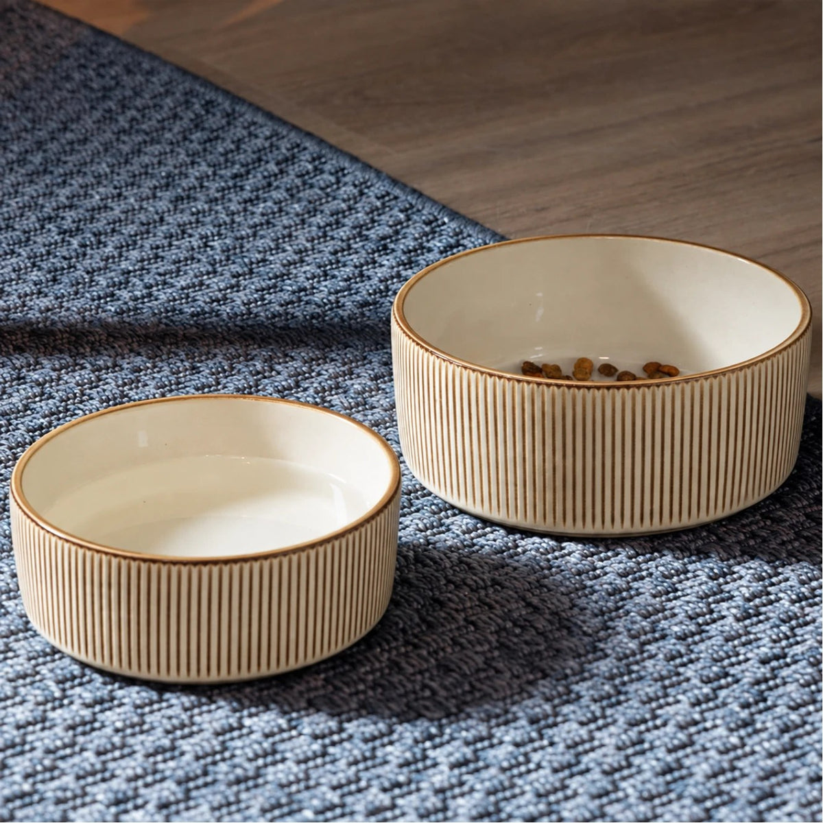 Large and small sand ceramic bowls on a rug